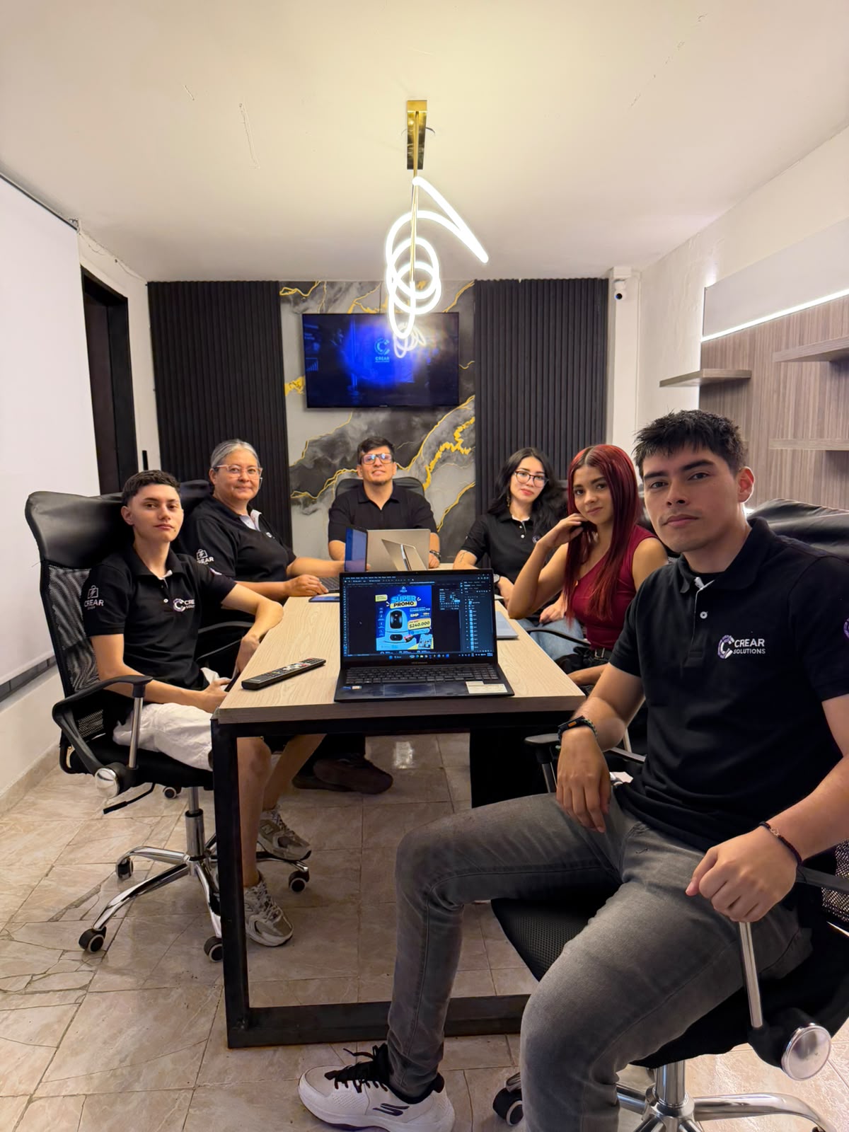 Equipo CREAR Solutions reunido alrededor de la mesa de trabajo