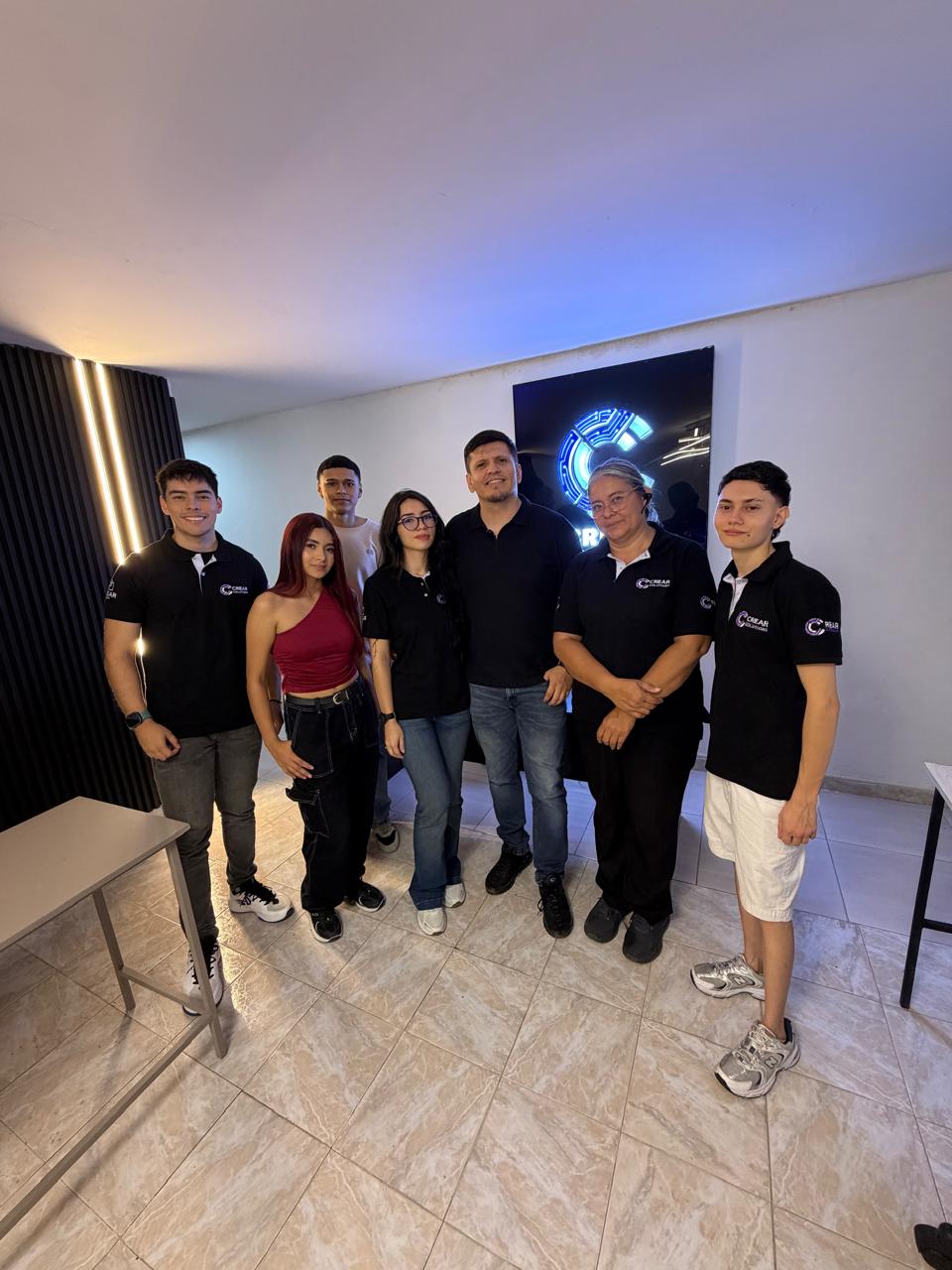 Equipo CREAR Solutions de pie en la oficina